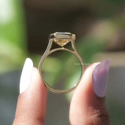 Back View of Emerald Cut Solitaire Engagement Ring In two fingers
