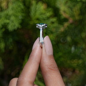 Side View of Green Hexagon Cut Gemstone Ring In two fingers