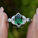 Front view of Green Hexagon Cut Gemstone Ring in two fingers 