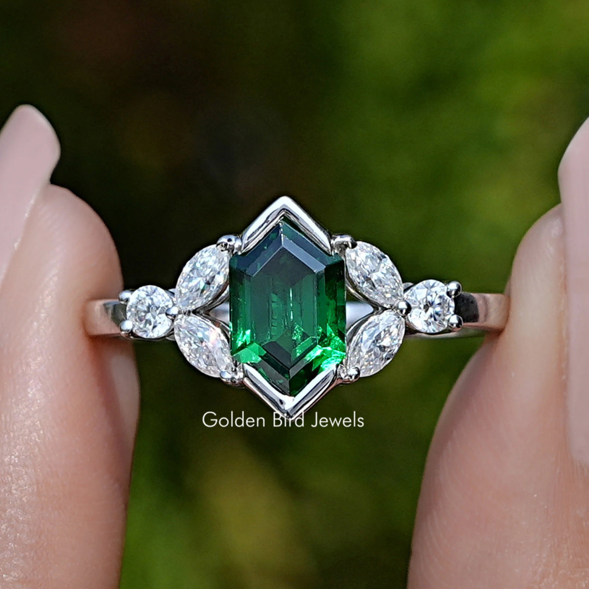 Front view of Green Hexagon Cut Gemstone Ring in two fingers 