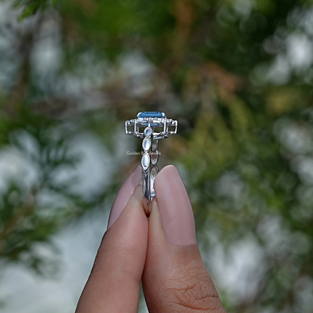 Side View of Emerald Cut Topaz Gemstone Ring In two fingers