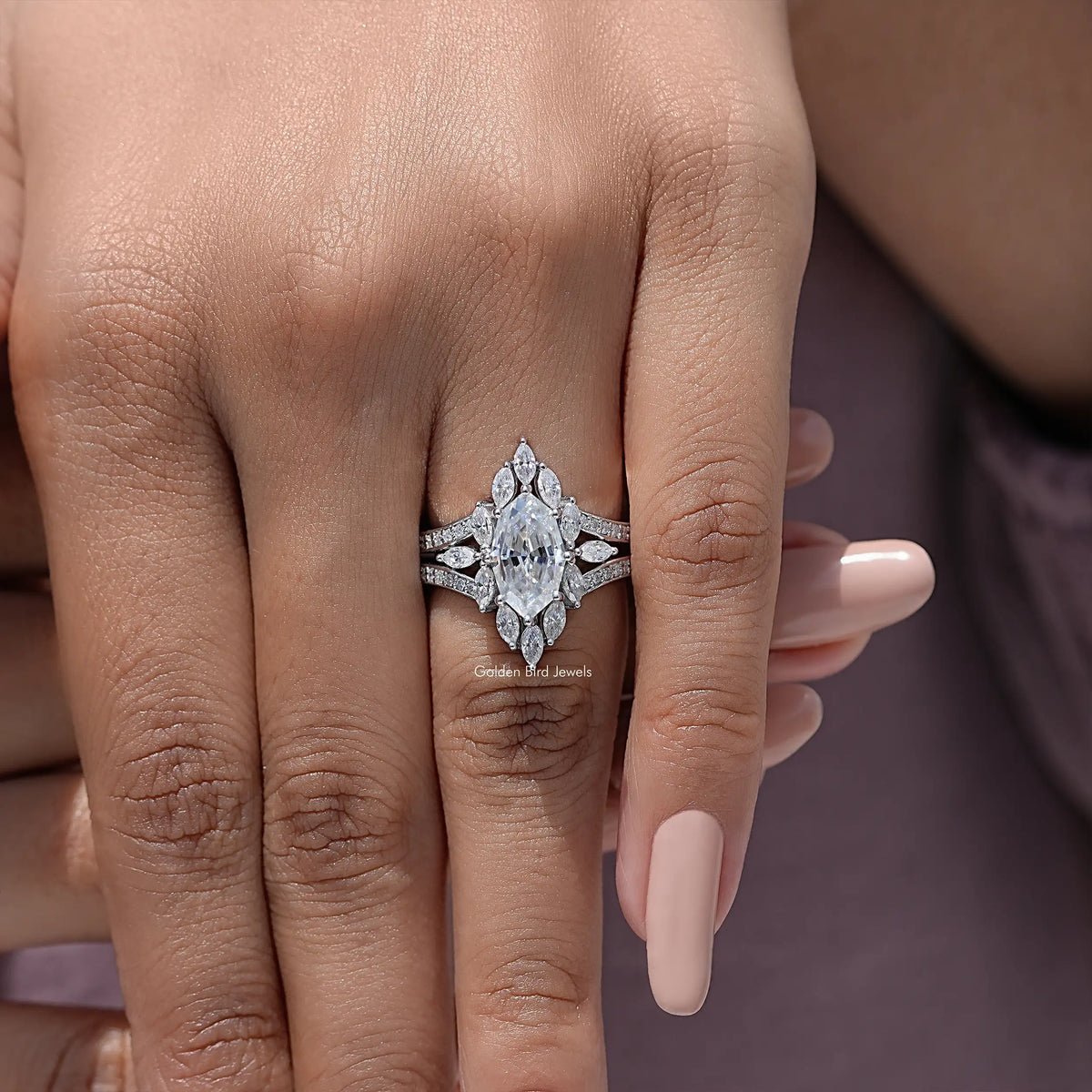 Marquise moissanite halo engagement ring with split band, close-up on finger