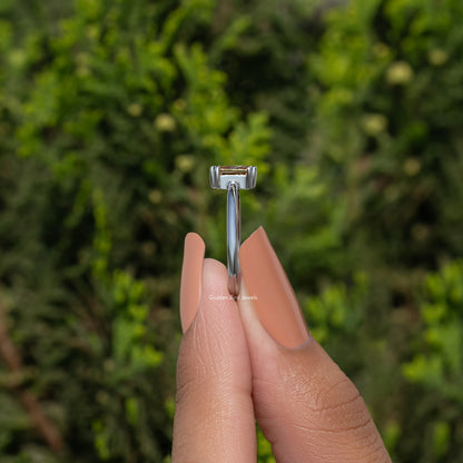 Silver ring with tall rectangular prong setting holding an orange gemstone