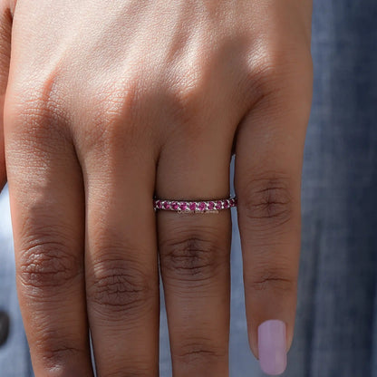 In finger front view of October Birthstone Pink Tourmaline Round Eternity Band in unique shape