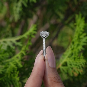 Side View of White Gold Heart Shaped Accent Diamond Ring In two fingers