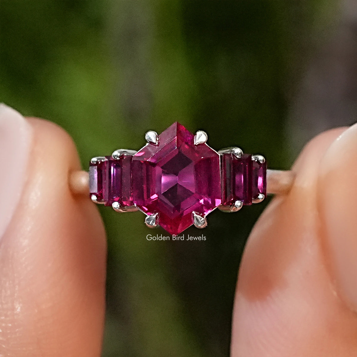 Five-stone ruby red hexagon-cut gemstone ring with prong-set side stones on silver band