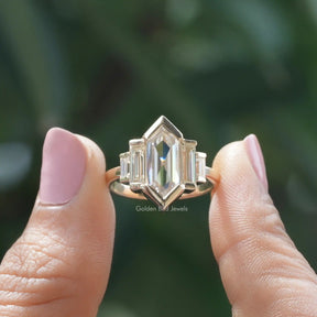 Two fingers holding the Hexagon Cut Moissanite Five Stone Ring