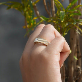 [Slightly folded finger front view of round cut solitaire engagement ring with 4 prongs]