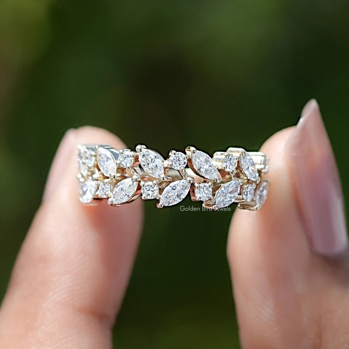 Marquise and Round Cut Lab Diamond Wedding Band Held Between Fingers