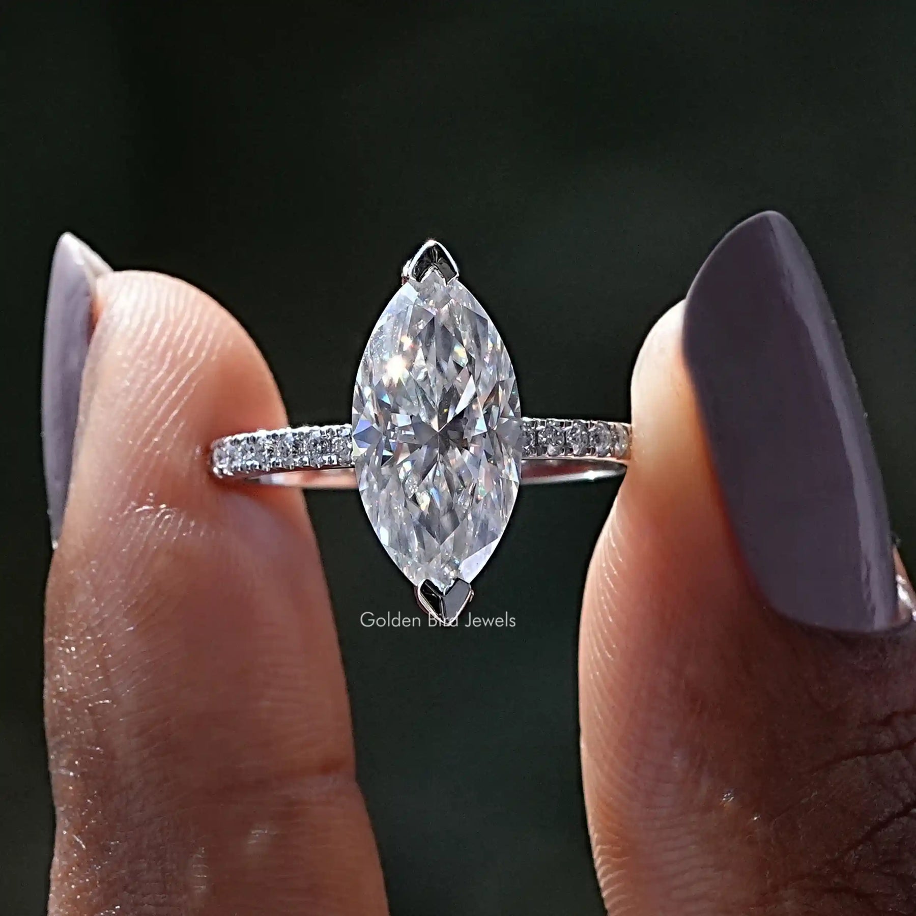 Two fingers holding the Marquise Cut Moissanite Solitaire Ring