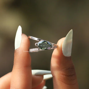 Two fingers holding the Split Shank Marquise Cut Moissanite Ring