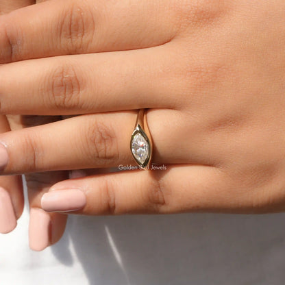 In finger front view of halo moissanite engagement ring in yellow gold 
