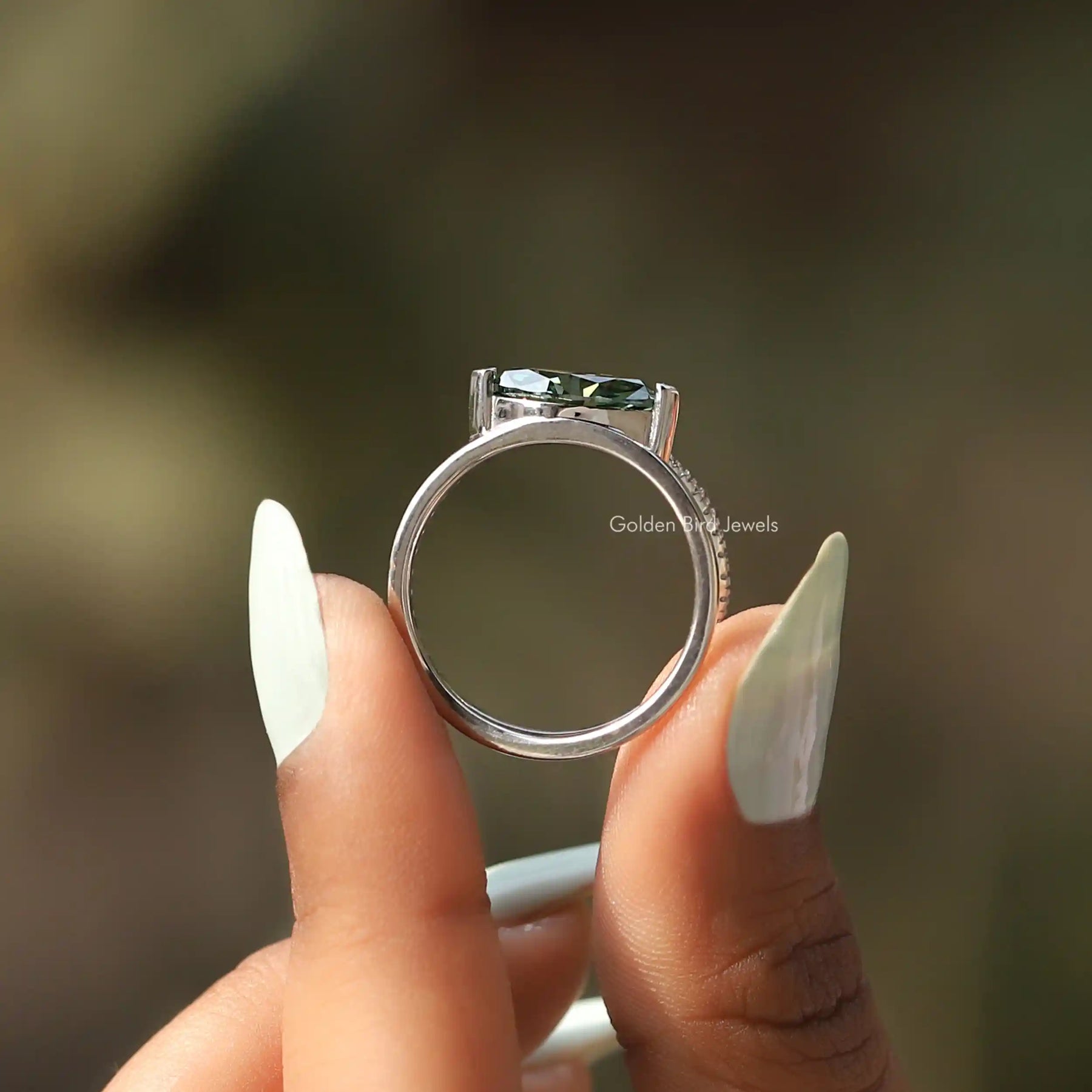 Back View of Green Marquise Cut Engagement Ring In two fingers