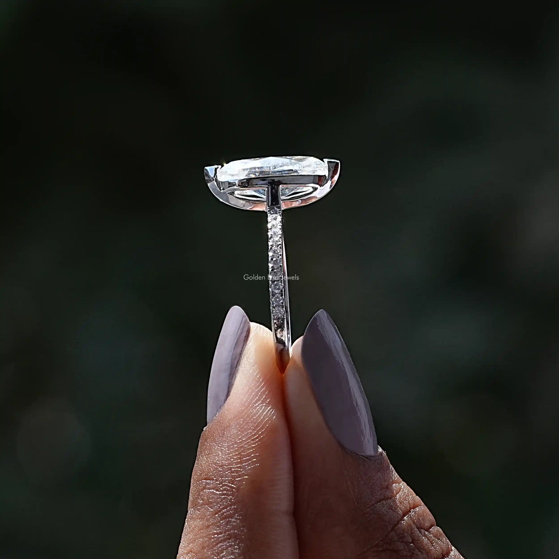 Side View of Moissanite Marquise Cut Engagement Ring In two fingers