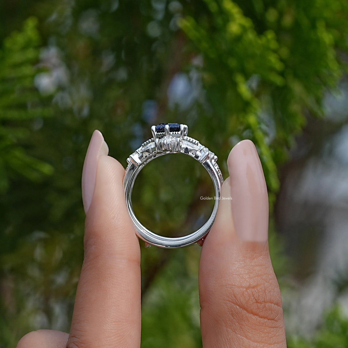Sterling silver ring side view with prong setting and dark center gemstone
