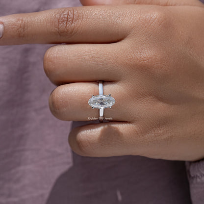 Oval moissanite solitaire ring on hand, four-prong center stone