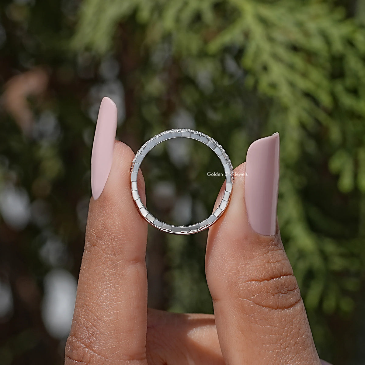 Silver round-stone ring band with visible inner circle from a side angle