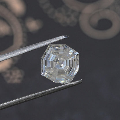Colorless cushion-cut moissanite loose gemstone held by metal tweezers, side view.