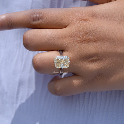 Yellow radiant-cut moissanite engagement ring with square center stone, close-up on hand