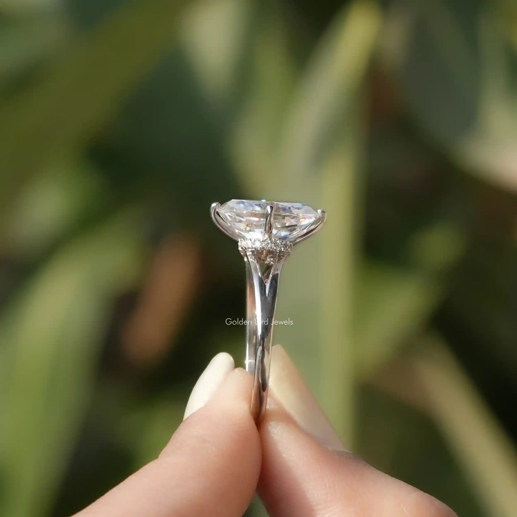 Side View of Crushed Ice Oval Cut Hidden Halo Ring In two fingers