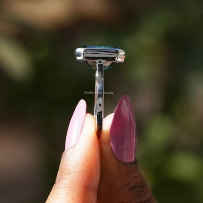 Side View of Green Emerald Cut Solitaire Ring In two fingers