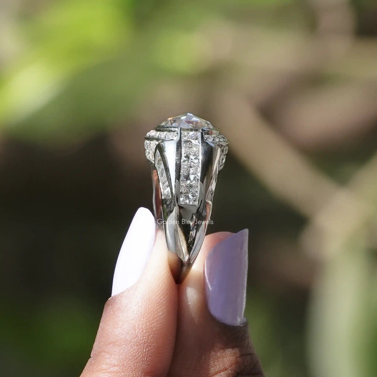 Side View of Oval Cut Halo Engagement Ring In two fingers