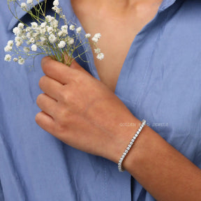 [In hand front view of round cut moissanite tennis bracelet crafted with white gold]-[Golden Bird Jewels]