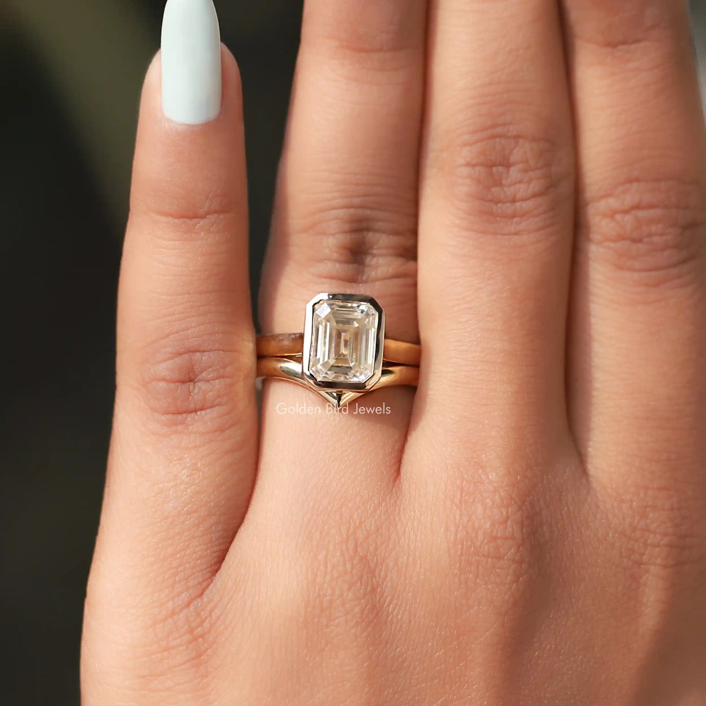 View of Emerald Cut Bezel Set Moissanite Ring In Yellow Gold
