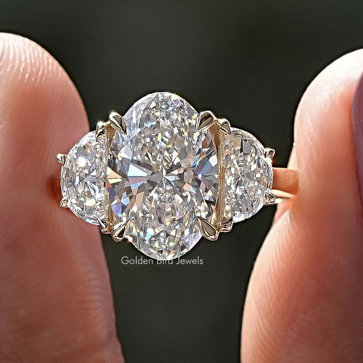 Front view of Oval Lab Diamond Three Stone Engagement Ring in two fingers 
