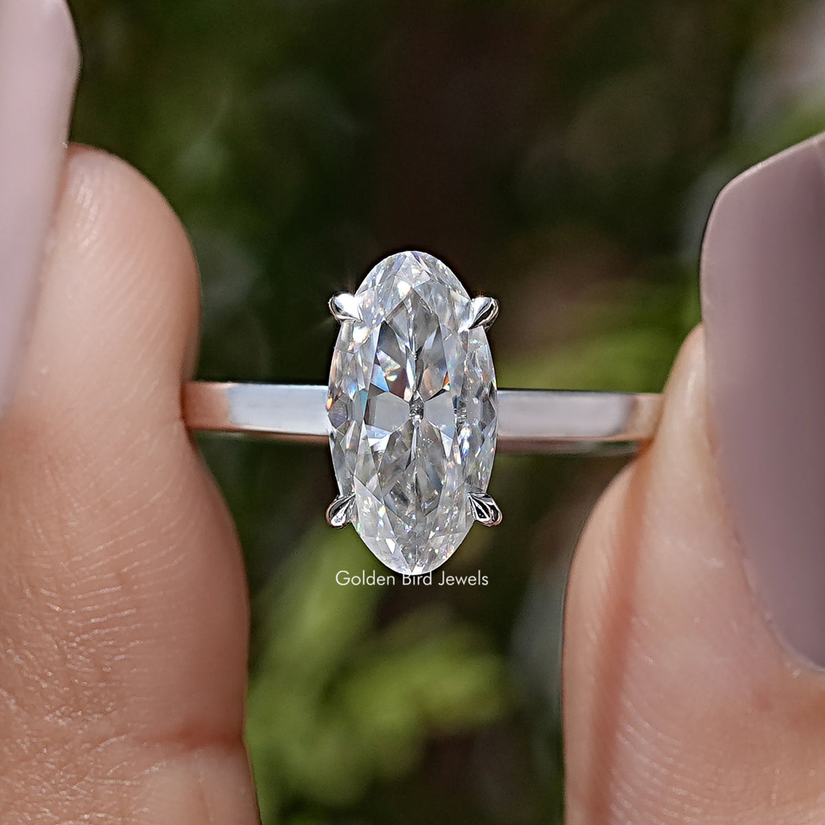 Oval moissanite solitaire ring with four-prong setting and slim band