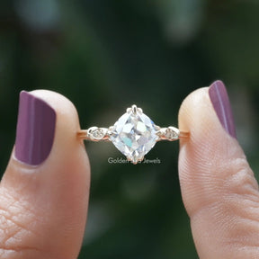 Two fingers holding the Old Mine Cushion Cut Moissanite Ring