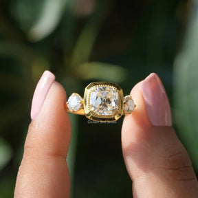 Two fingers holding the Old Mine Cushion Cut Moissanite Ring