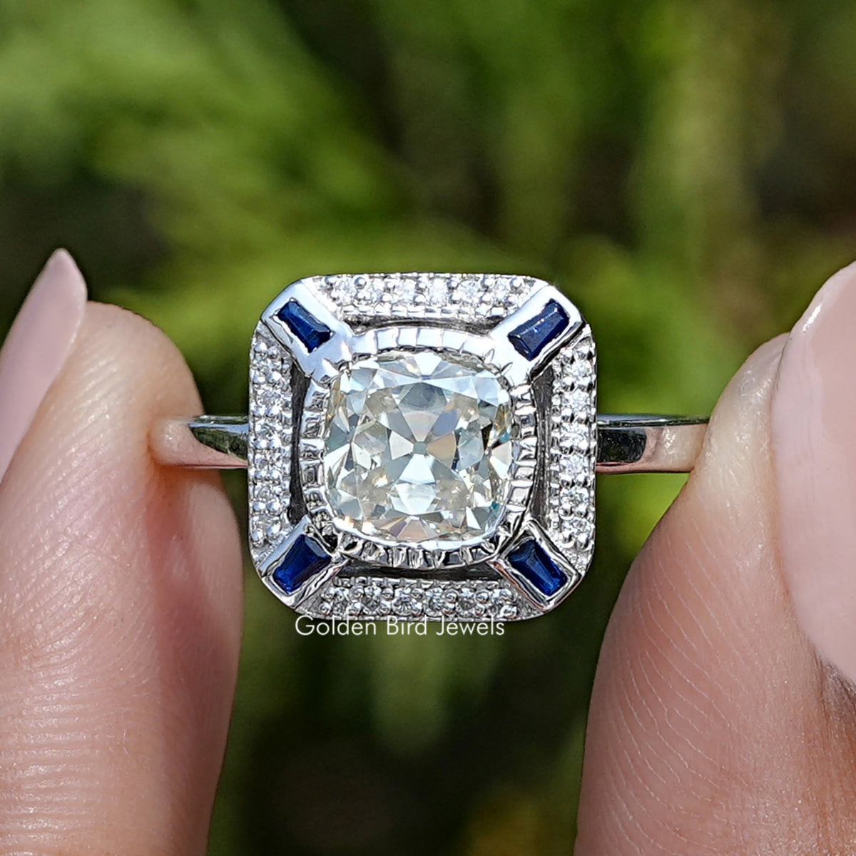 Front view of Old Mine Cushion Cut Moissanite Halo Ring in two fingers 