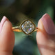 Two fingers holding the Old Mine Cushion Cut Moissanite Ring