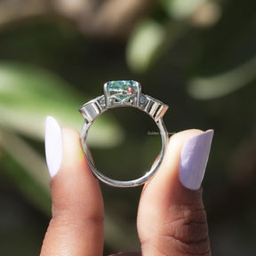 Back View of Pear Cut Moissanite Three Stone Ring In two fingers