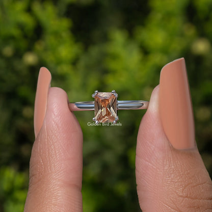 Silver ring with orange faceted gemstone center and prong-set shoulders