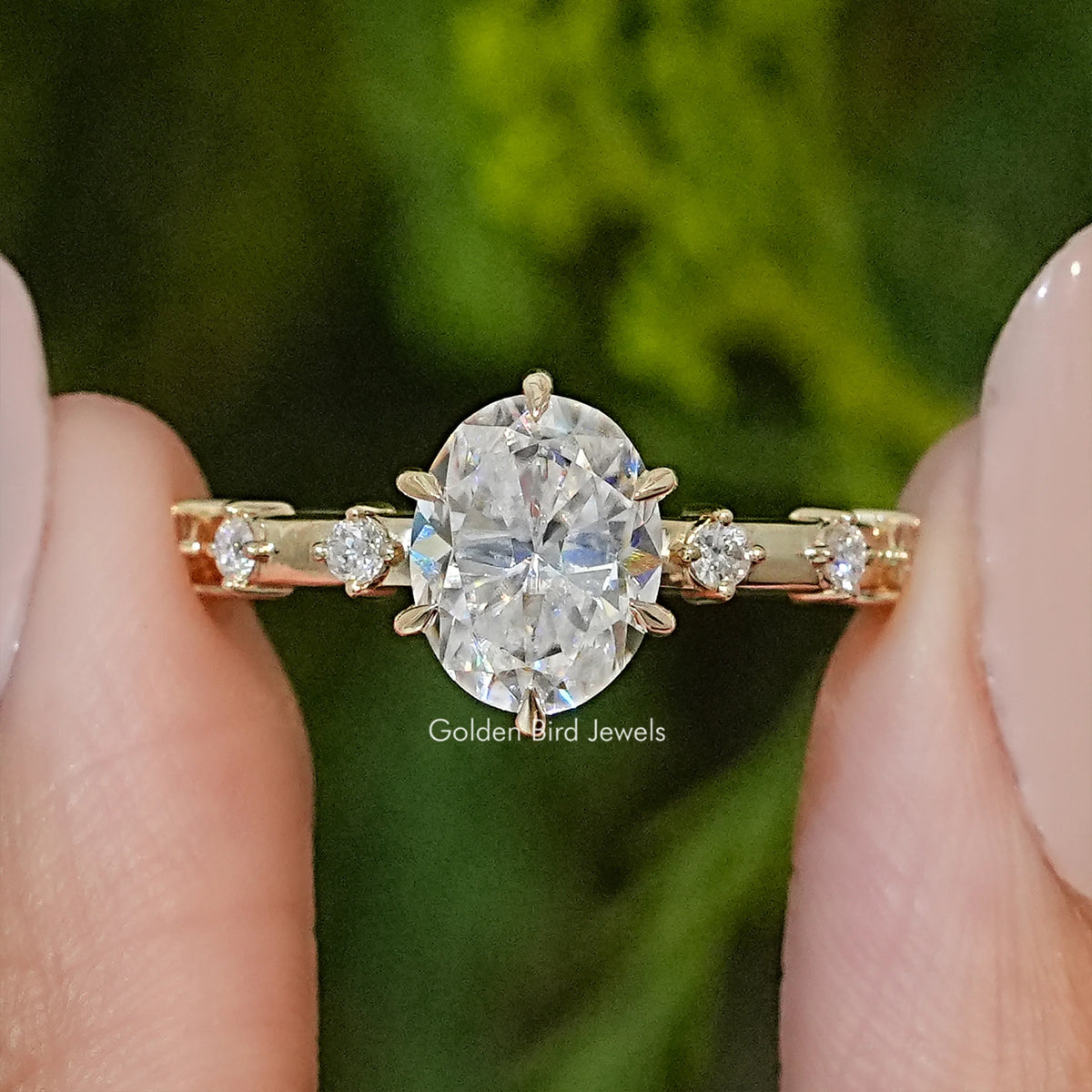 Oval-cut moissanite engagement ring with prong-set oval center and side stones