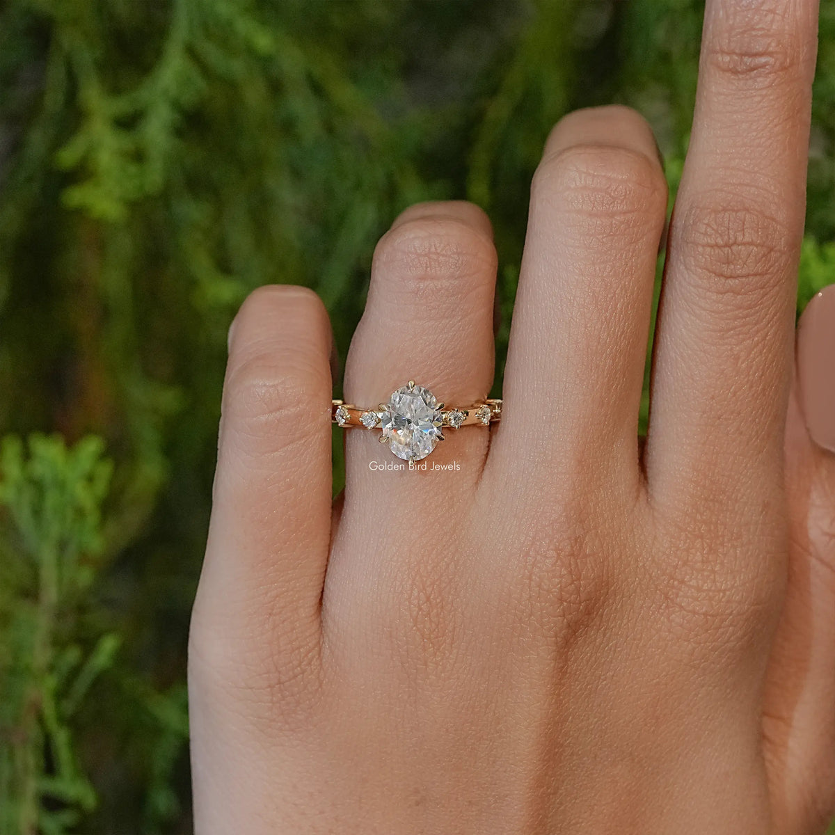Oval-cut moissanite engagement ring with side accents and prong-set center stone