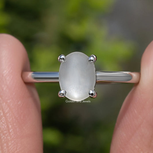 Oval moonstone solitaire ring detail, oval gemstone between four small prongs