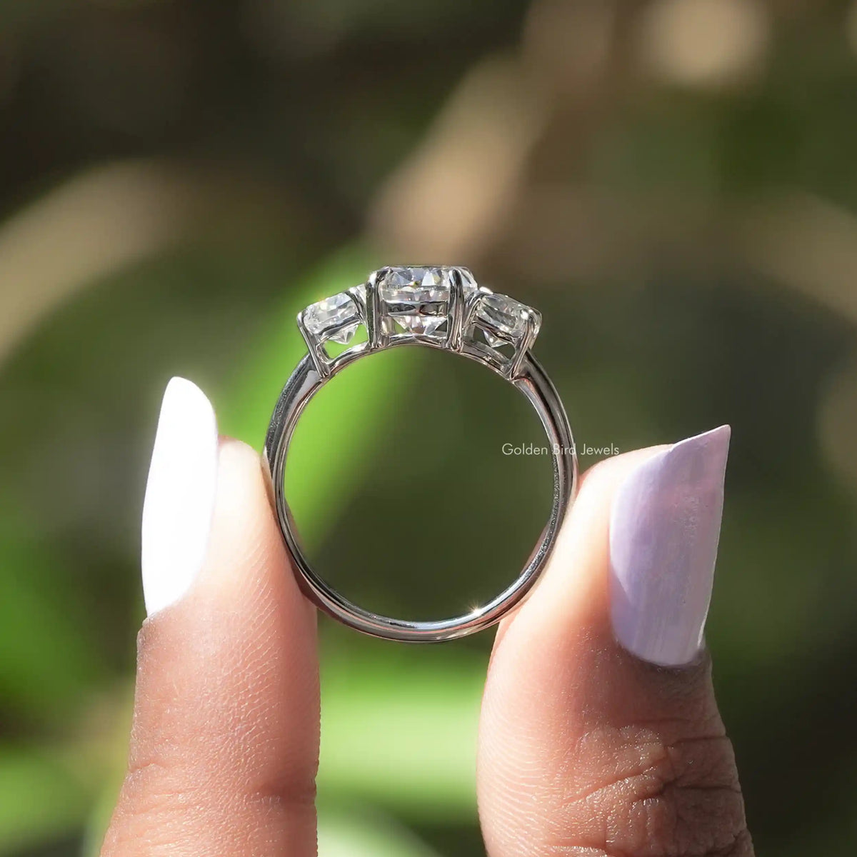 Back View of Moissanite Oval And Half Moon 3 Stone Ring In two fingers