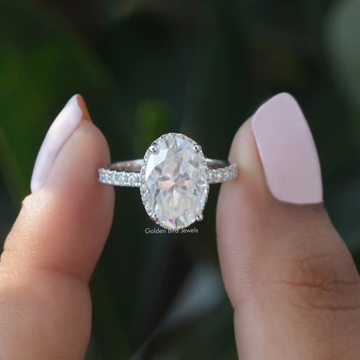 Two fingers holding the Moissanite Hidden Halo Engagement Ring