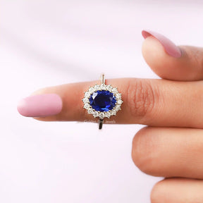 Close-Up View Of Oval Cut Halo Blue Sapphire Ring in a finger