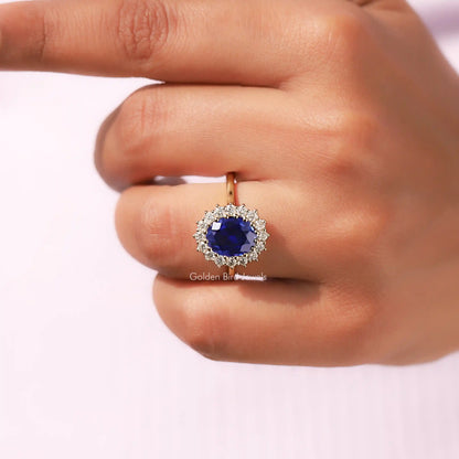 Close-Up View Of Oval Cut Halo Engagement Ring In a Finger