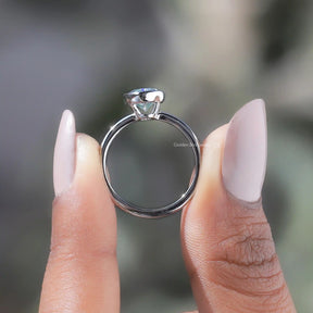 Back View of Oval Cut Moissanite Bezel Setting Solitaire Ring In two fingers
