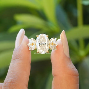 Front View of Oval Cut Moissanite Cluster Engagement Ring In two Fingers