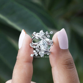 Two fingers holding the Oval Cut Twisted Shank Moissanite Ring