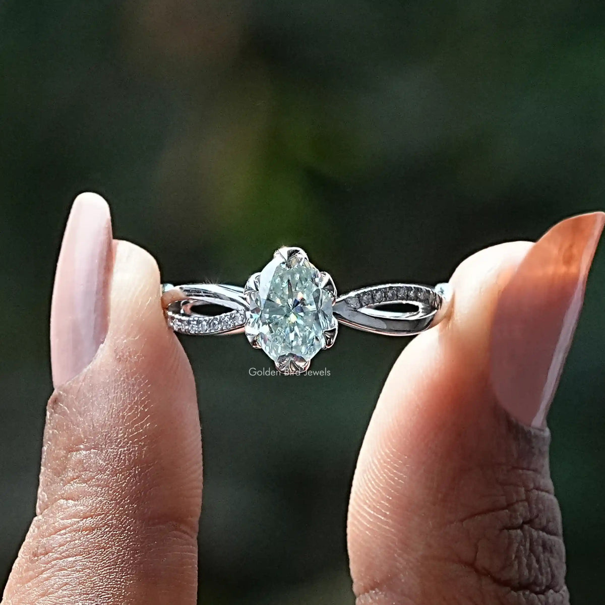 Two fingers holding the Oval Cut Moissanite Shank Engagement Ring