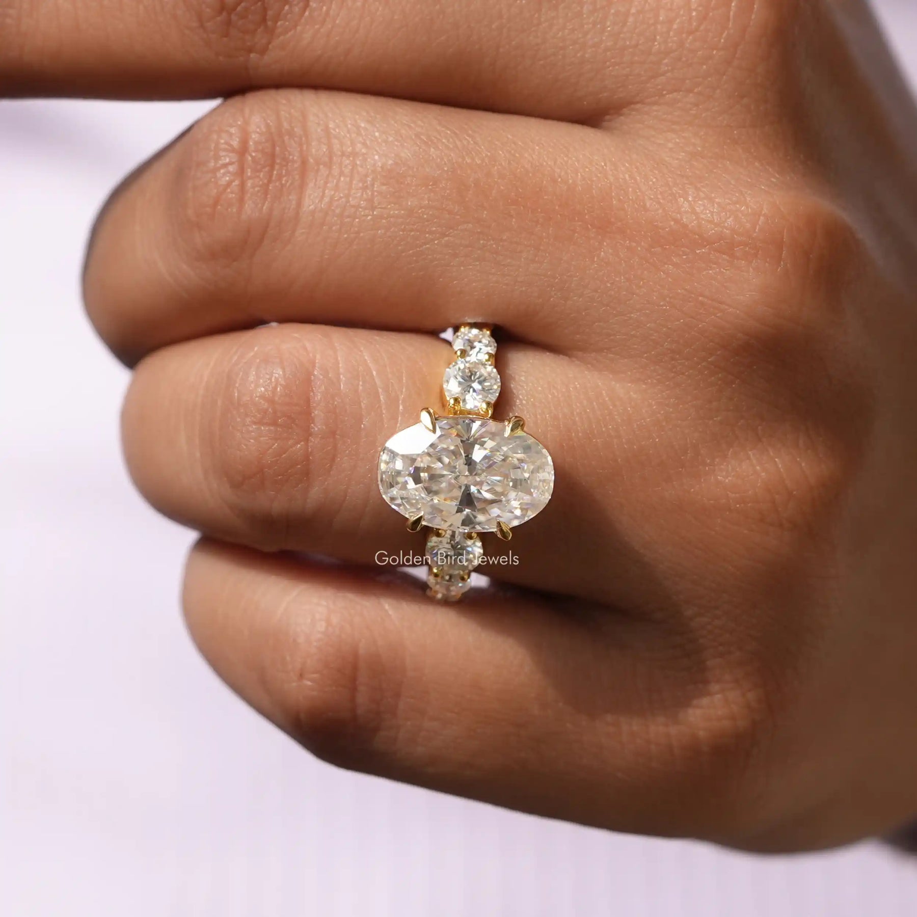 [In finger front view of moissanite oval and roiund cut engagement ring]-[Golden Bird Jewels]