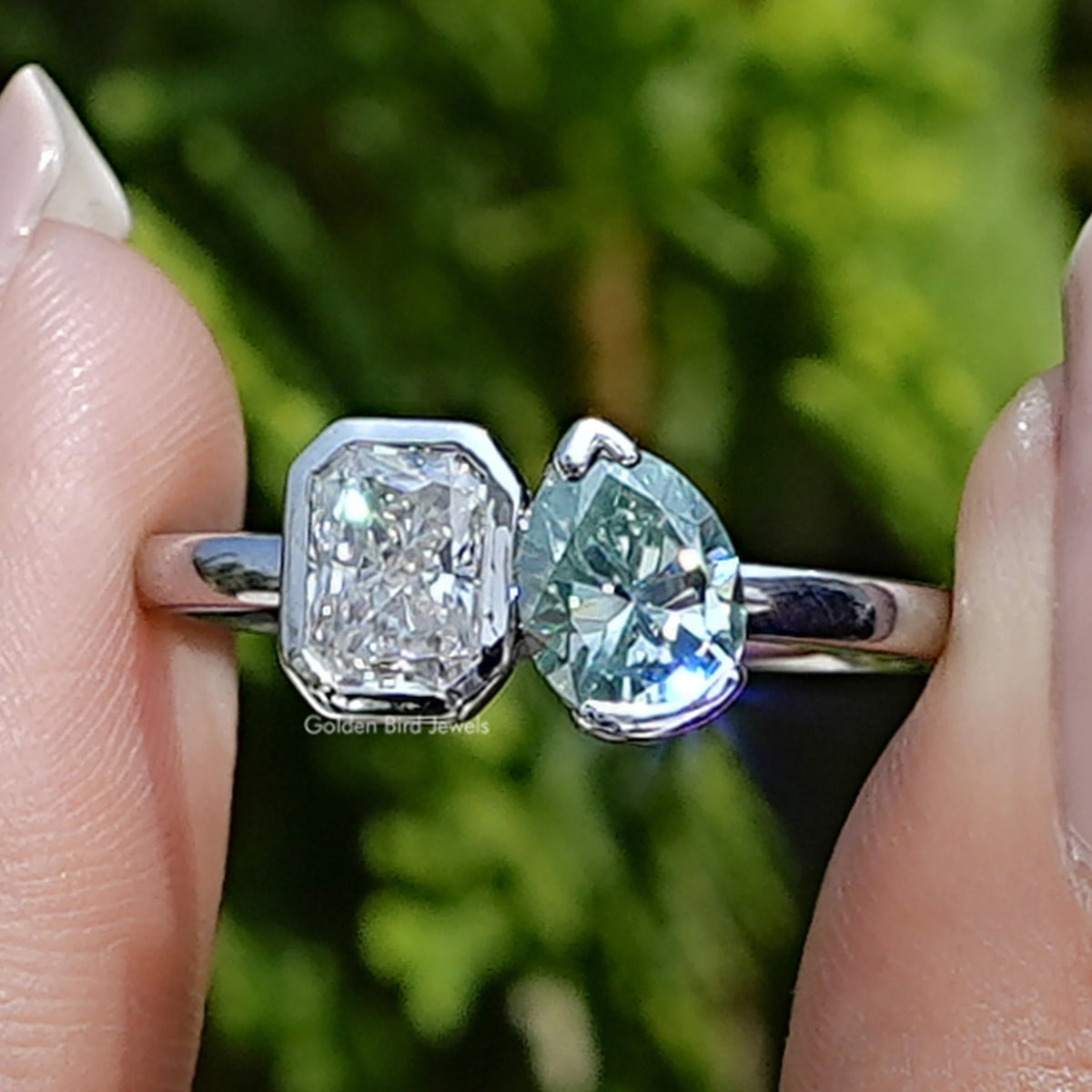 Front view of Pear And Radiant Moissanite Toi Et Moi Ring Set in two fingers 