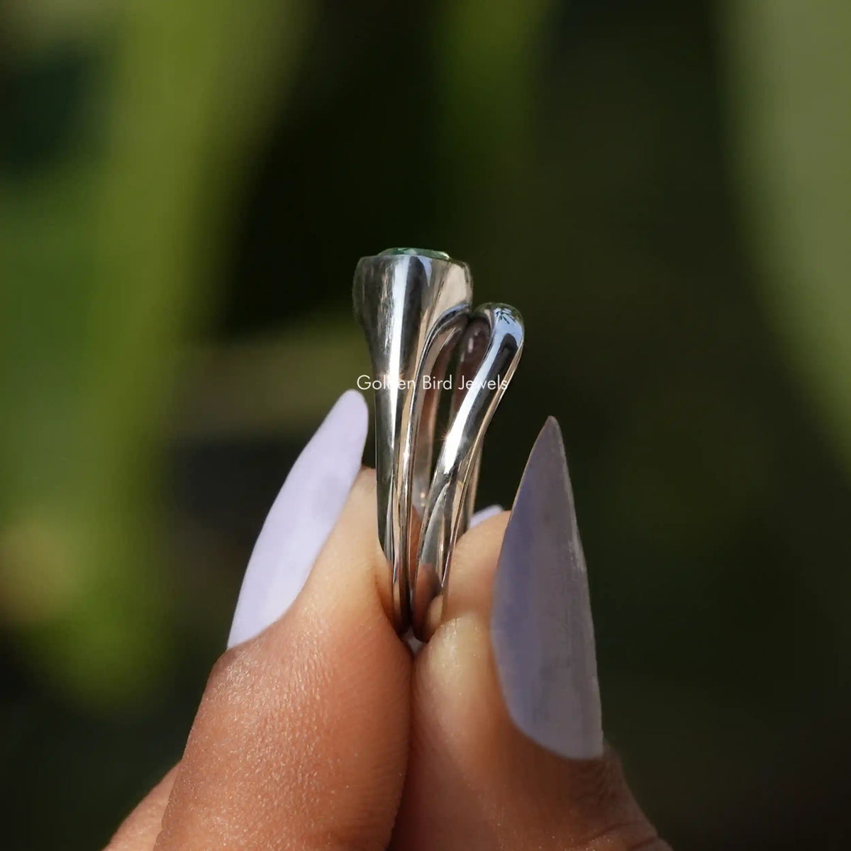 Side View of Pear Cut Solitaire Engagement Ring In two fingers